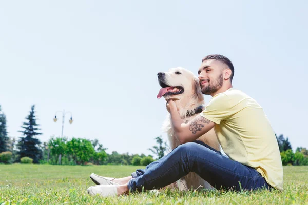Красивый парень со своей собакой — стоковое фото