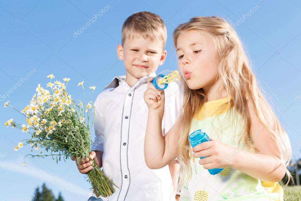 Positive children blowing soup bubbles 