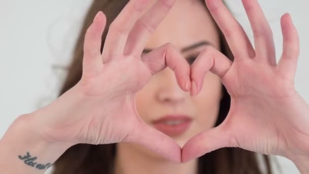 Крупный план девушки с пальцами на сердце — стоковое видео