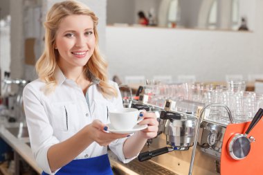 Young smiling female standing with coffee
