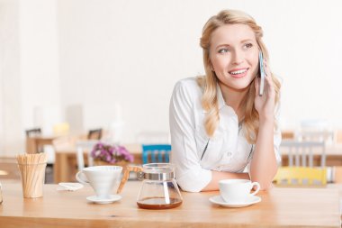 Pretty young waitress talking per mobile phone