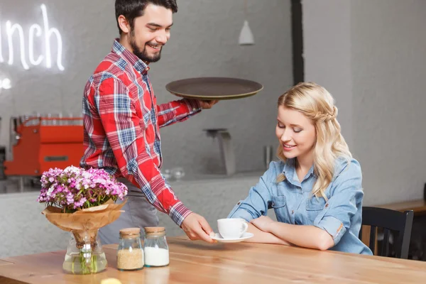 Camarero guapo dando taza de café a la mujer — Foto de Stock