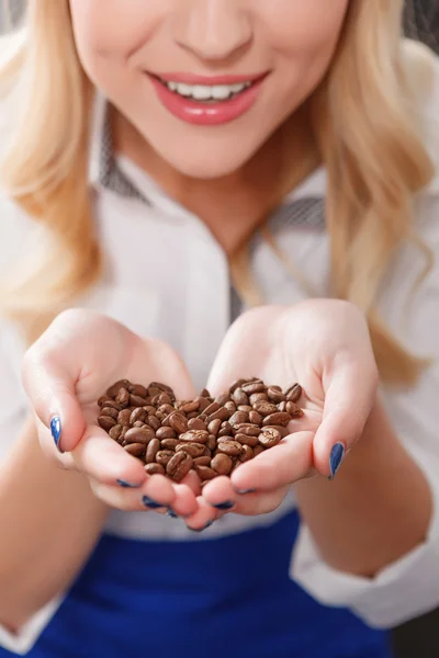 Close up de mulher loira segurando grãos de café — Fotografia de Stock