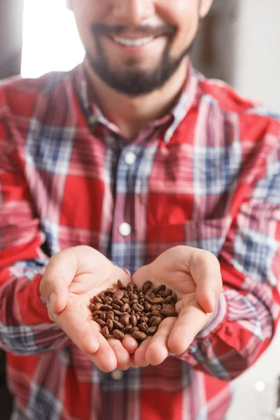 Close up of man holding coffee beans — Stock Photo, Image