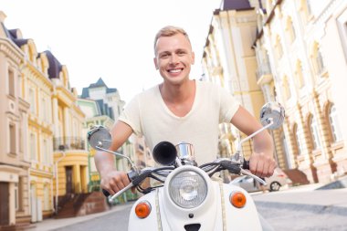 Smiling blond-haired man on scooter 