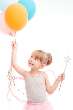 Smiling little girl looking at balloons