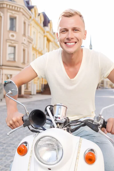 Smiling blond-haired man on scooter — Stok fotoğraf