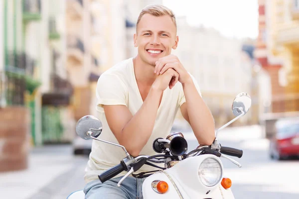 Blond-haired man leaning on scooter — Stok fotoğraf