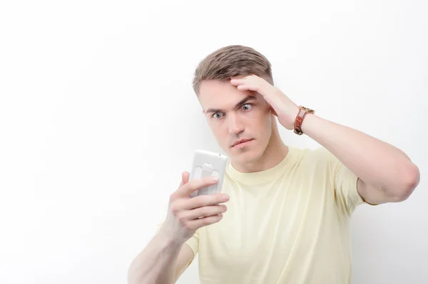 Confused man looking at his mobile phone — Stock Photo, Image