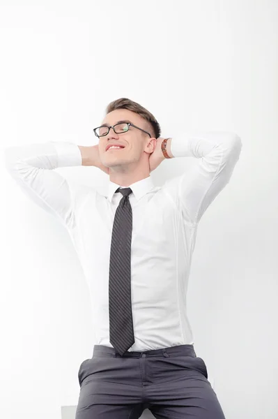 Businessman standing with arms behind head — Stock Photo, Image