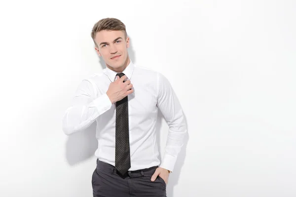Affärsman fastställande hans slips på isolerade bakgrund — Stockfoto