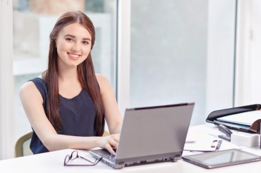 Upbeat girl sitting with laptop 