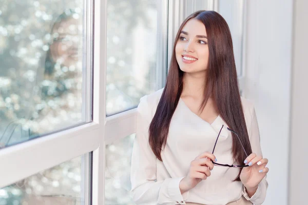 Pleasant woman standing near window — 图库照片