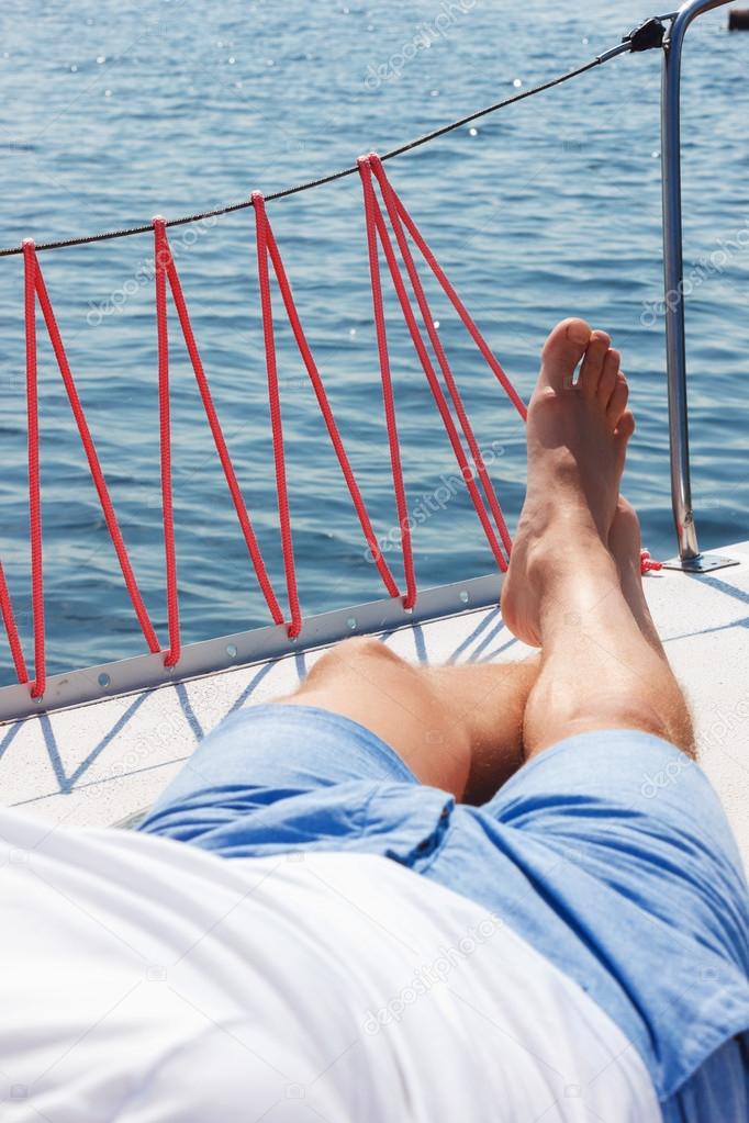 Nice man lying on yacht deck 