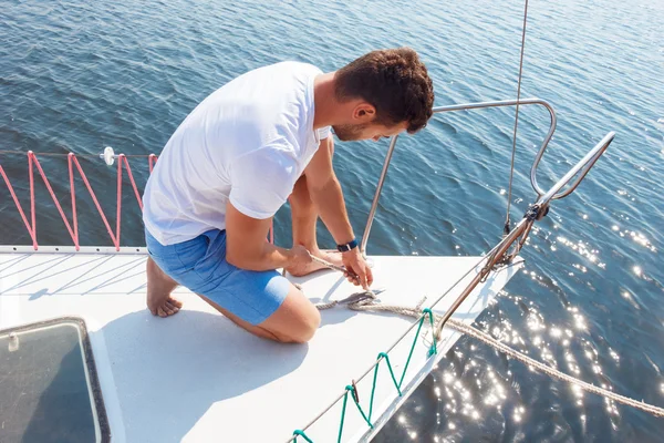 Hombre positivo ajustando su yate —  Fotos de Stock