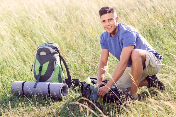 Young tourist  fastening his bag