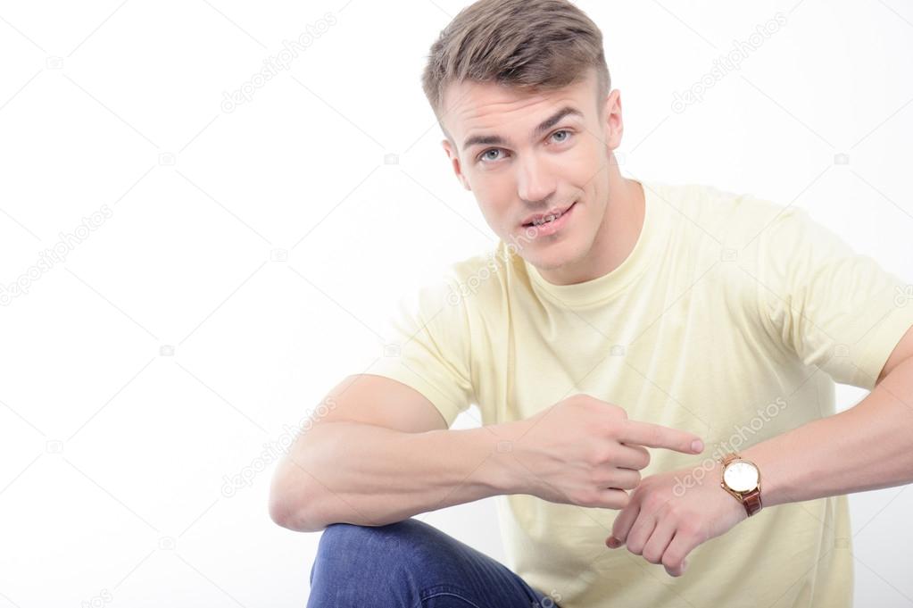 Young handsome man pointing on his watch