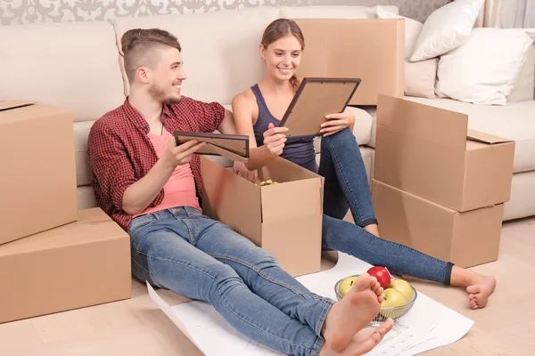 Young couple unpacking boxes — Stock Photo, Image