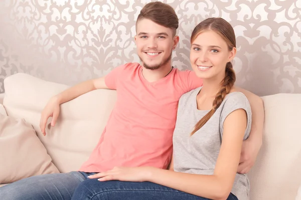 Jeune couple assis sur le canapé — Photo