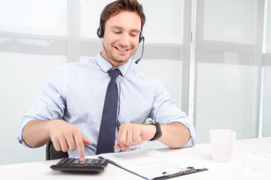 Call center operator counting on calculator 
