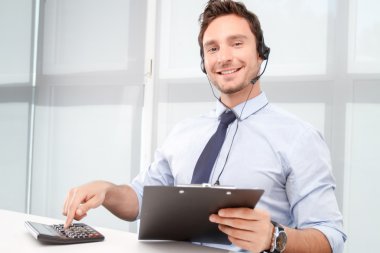 Call center operator counting on calculator 