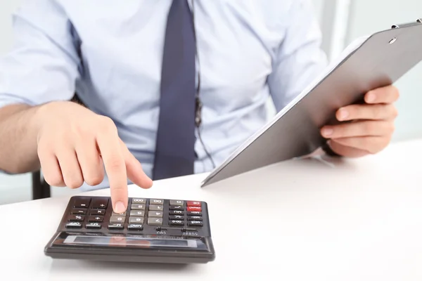 Operador del centro de llamadas contando con calculadora — Foto de Stock