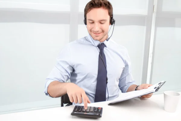 Call center operator counting on calculator — Stock Photo, Image