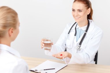 Gülümseyen kardiyolog hastayla konuşuyor 