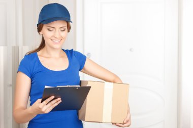 Güzel deliverywoman ayakta kapı yakınındaki 