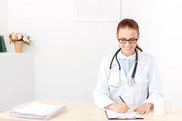 Odborný lékař sedí u stolu — Stock fotografie