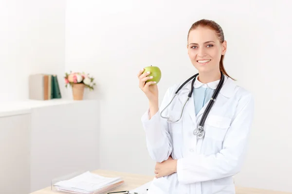 Pozitif doktor holding yeşil elma — Stok fotoğraf
