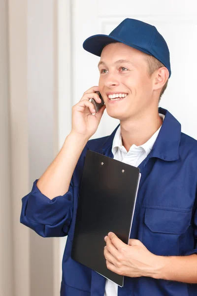 Deliveryman talking on mobile phone — Stock Photo, Image