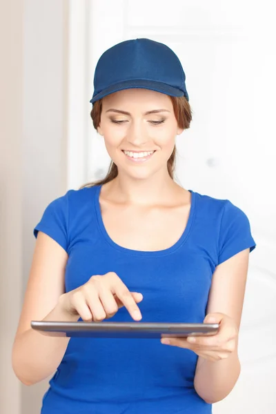 Nice deliverywoman standing near door — Stock Photo, Image