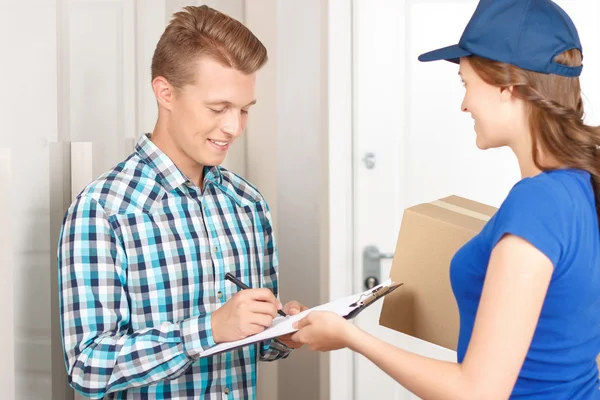 Positive deliverywoman delivering parcel — Stock Photo, Image