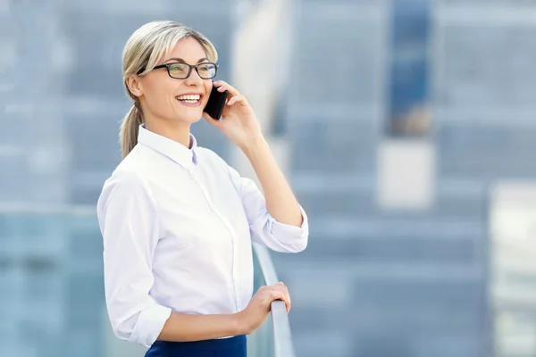 Pleasant businesswoman talking on mobile phone