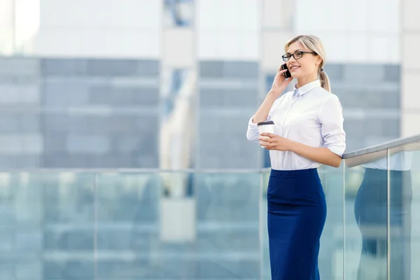 Wanita bisnis tersenyum memegang telepon — Stok Foto