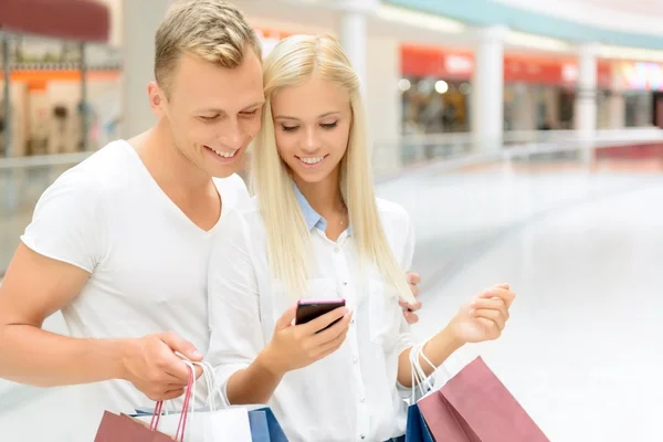 Pareja positiva sosteniendo paquetes — Foto de Stock