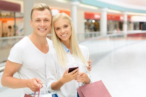 Pareja positiva sosteniendo paquetes — Foto de Stock