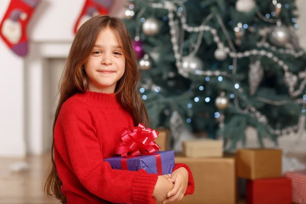 Szép lány játszani a karácsonyfa közelében — Stock Fotó