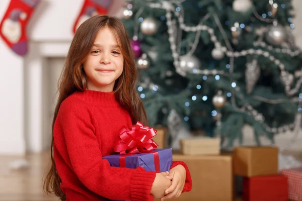 Leuk meisje spelen in de buurt van de kerstboom Stockfoto