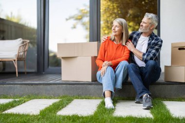 Mutlu Kafkasyalı son sınıf çifti evlerinin dışında kutuları taşıyorlar.