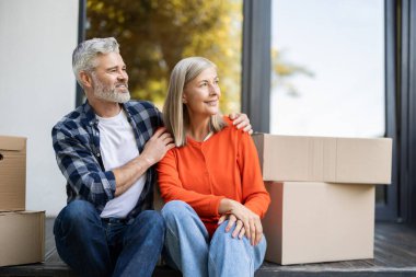 Olgun, beyaz bir çift taşındıktan sonra verandada, paketlenmiş kutuların yanında dinleniyor.