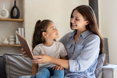 Genç kızı olan bir kadın evde alet kullanırken bağ kuruyor.