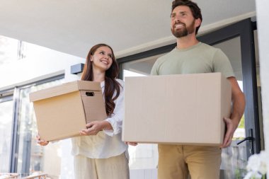Yeni konaklama yeri. Çift yeni bir eve taşınırken karton kutular taşıyor.
