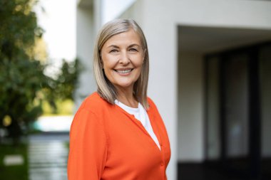 Olgun bir kadın. Olgun sarışın bir kadının kendini iyi ve pozitif hisseden portresi.