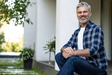 Huzurlu bir sabah. Gri saçlı, olgun bir adam evinin bahçesinde oturuyor ve sabah kahvesini içiyor.