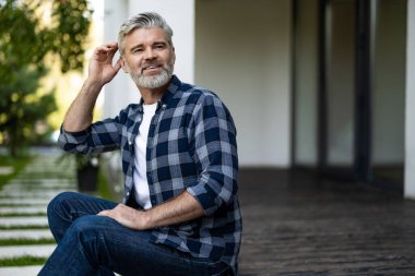 Huzurlu bir sabah. Gri saçlı, olgun bir adam evinin bahçesinde oturuyor ve sabah kahvesini içiyor.