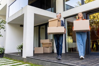 Mutlu son sınıf erkek ve kadın çifti taşınıyor. Kutuları taşıyorlar.