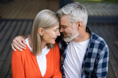 Şefkatle sarılın. Gri saçlı sakallı adam kadına nazikçe sarılıyor ve ikisi de rahatlamış hissediyor.