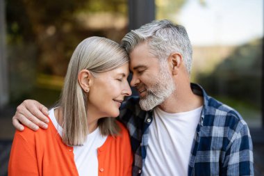 Şefkatle sarılın. Gri saçlı sakallı adam kadına nazikçe sarılıyor ve ikisi de rahatlamış hissediyor.